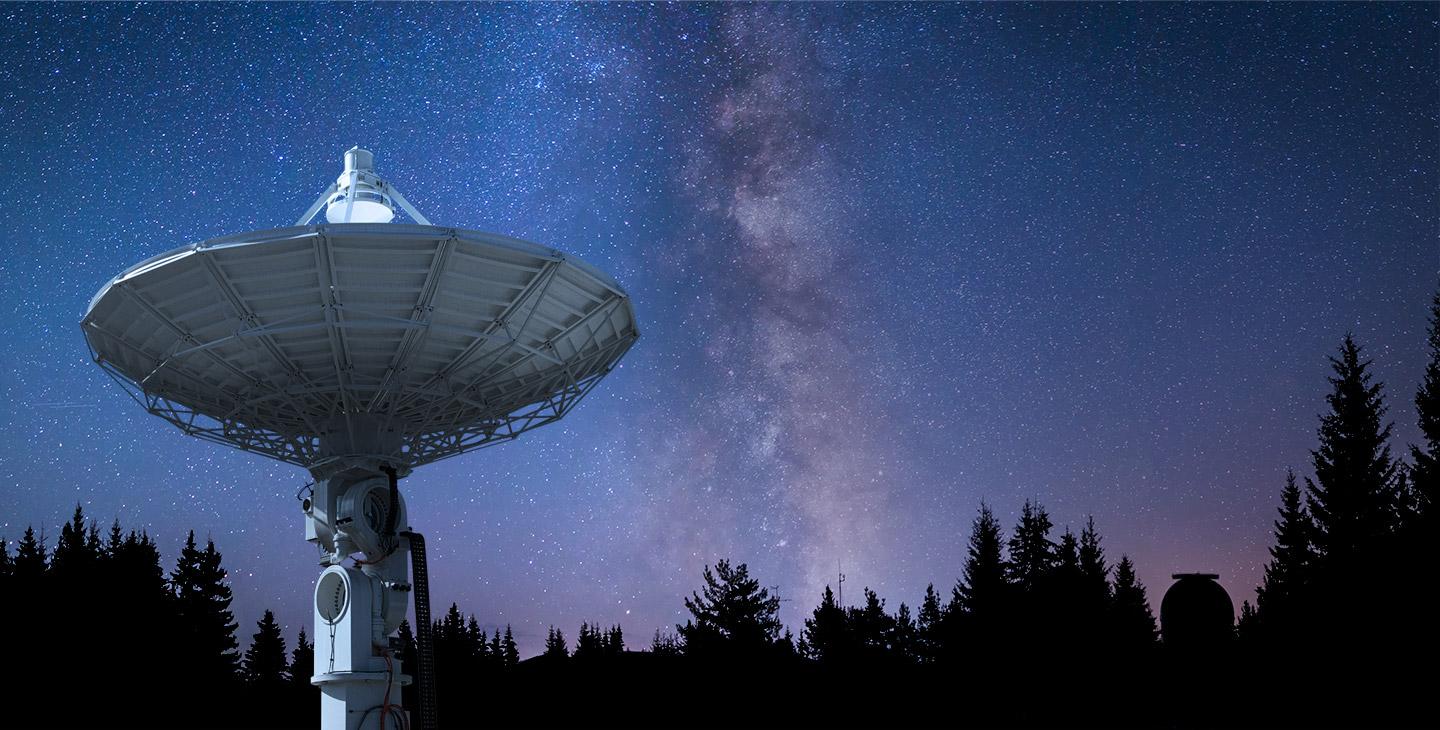 Viasat ground station pointed at the night sky against a backdrop of stars