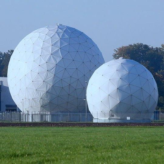 One large and one small radome containing isr systems, secured behind fencing