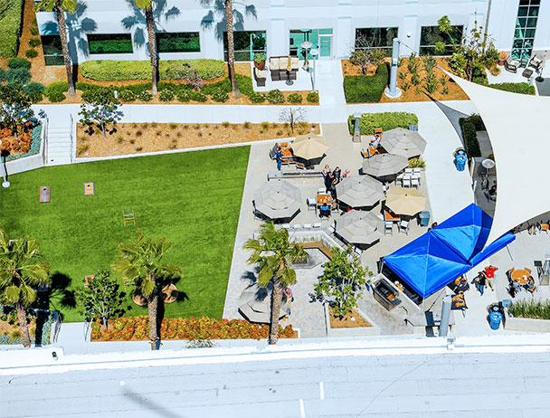 Aerial view of umbrella shaded tables on the courtyard at the Carlsbad campus