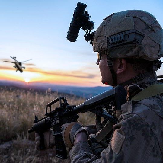 Warfighter standing and looking at helicopter flying away